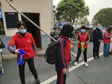 新矿村社区市妇联疫情防控联络员蒋嫦为学生进行消毒_副本.jpg